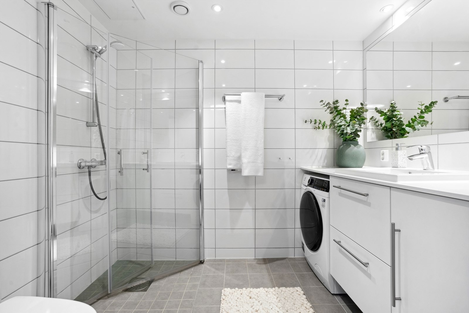 Baderom med moderne fasiliteter, inkludert dusj og plass for vaskemaskin. Galleribilde