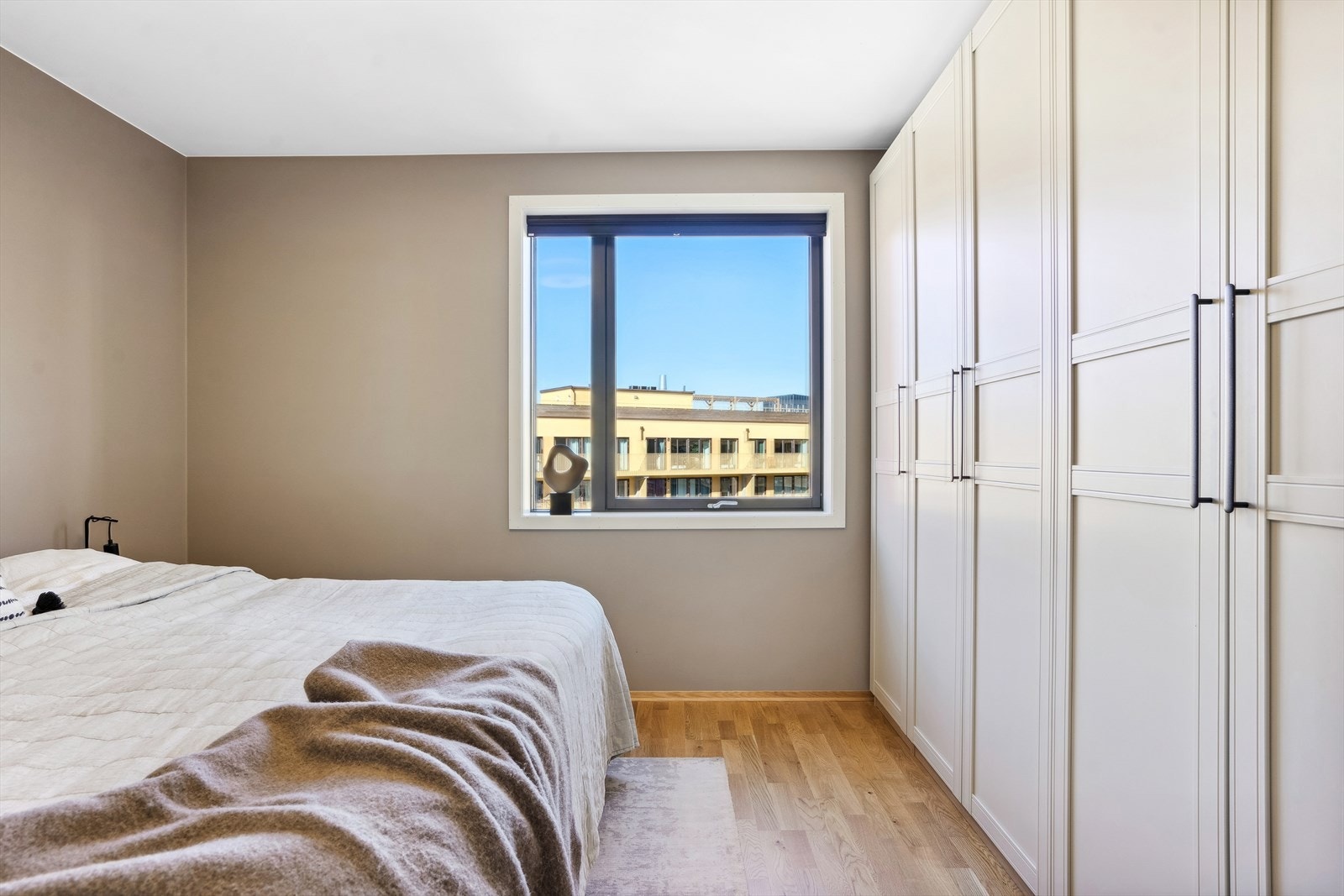 Soverom med stor plass til oppbevaring og minimalistisk design. Galleribilde