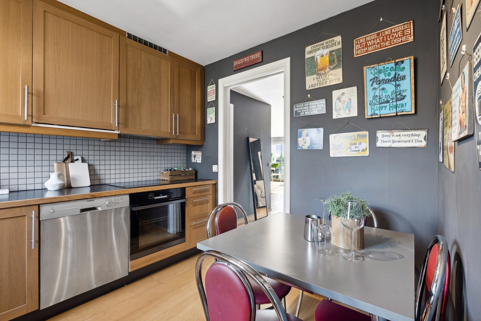 Kjøkken med spiseplass. Innredning med profilerte fronter. Benkeplaten er av laminat med nedfelt kum i stål. Det er opplegg for kjøl/fryseskap, oppvaskmaskin, integrert platetopp og stekeovn. Det er kjøkkenventilator med avtrekk via felles luftekanal. Galleribilde