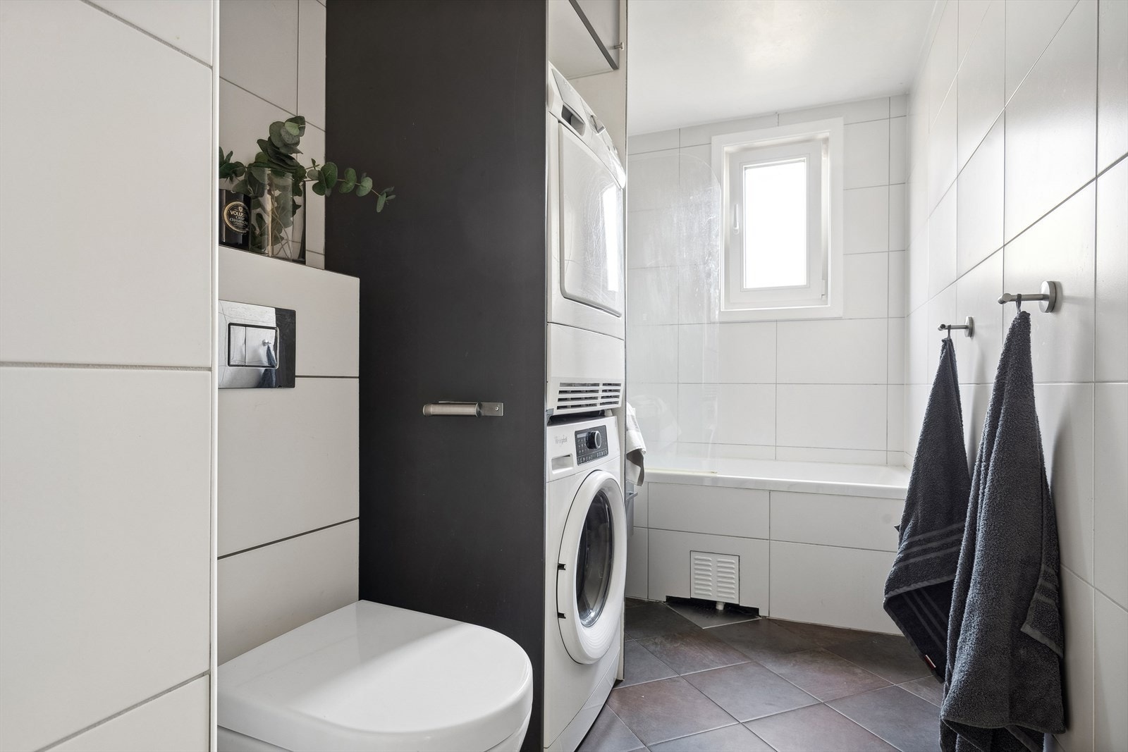 Innredning med nedfelt servant. Innmurt badekar. Veggmontert armatur og garnityr. Opplegg for vaskemaskin. Veggmontert toalett. Galleribilde