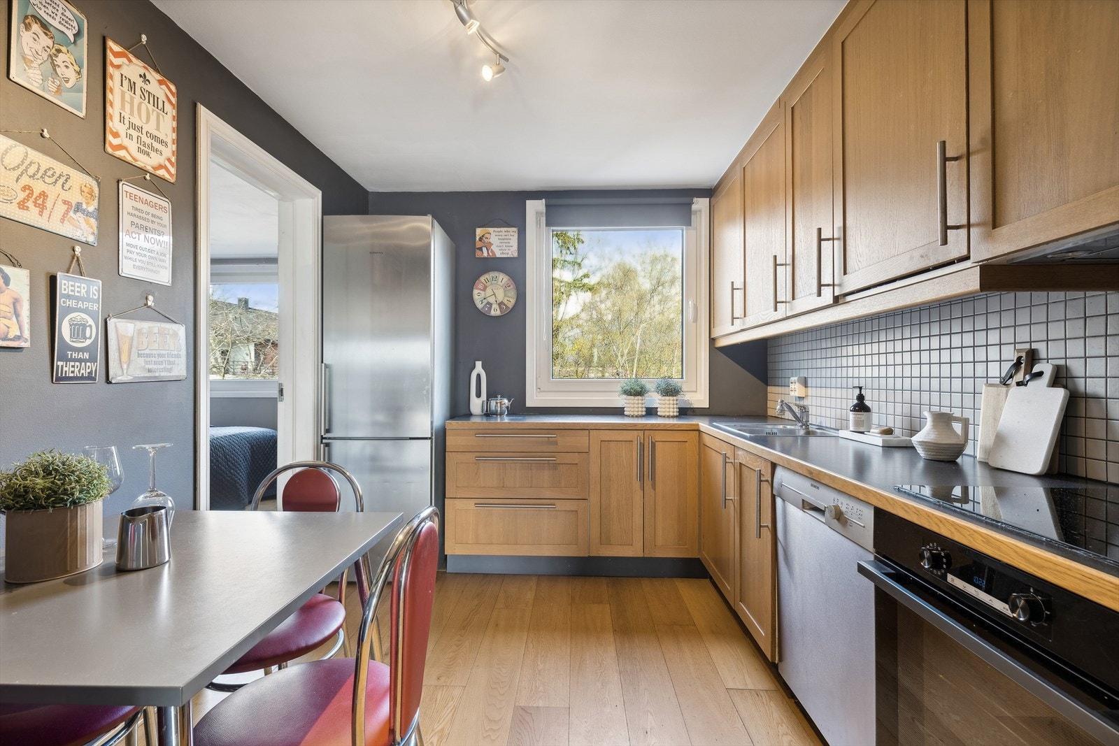 Kjøkken med spiseplass. Innredning med profilerte fronter. Benkeplaten er av laminat med nedfelt kum i stål. Det er opplegg for kjøl/fryseskap, oppvaskmaskin, integrert platetopp og stekeovn. Det er kjøkkenventilator med avtrekk via felles luftekanal. Galleribilde