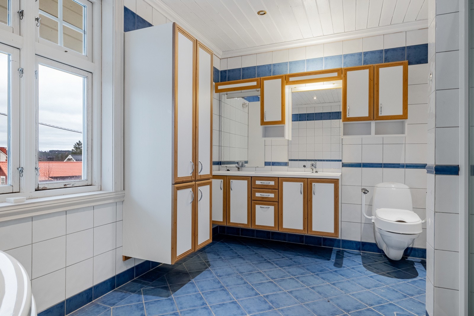 Badet er innredet med servant på innredning, toalett, boblebadekar og dusjhjørne. Galleribilde