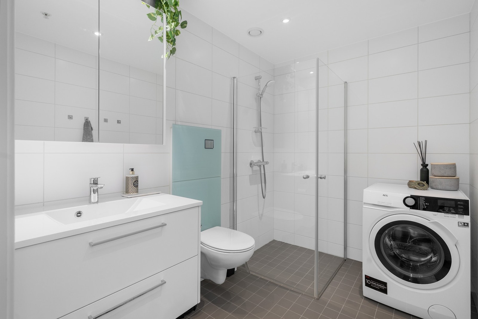 bad med vegghengt wc og opplegg til vaskemaskin Galleribilde