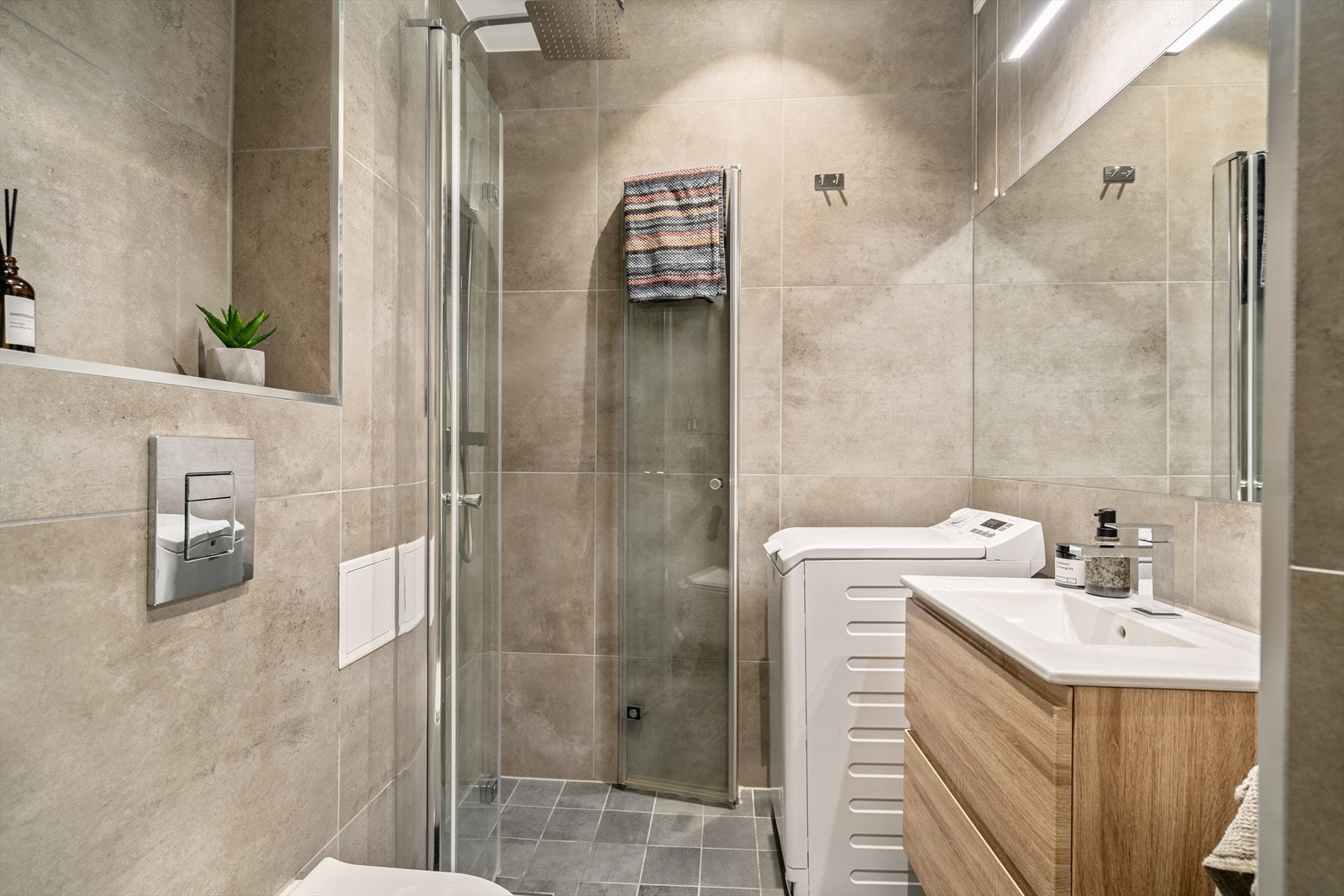 Lekkert helfliset baderom fra 2019 med gulvvarme og innfelte lys i himling. Her er både plass og opplegg for vaskemaskin. Galleribilde