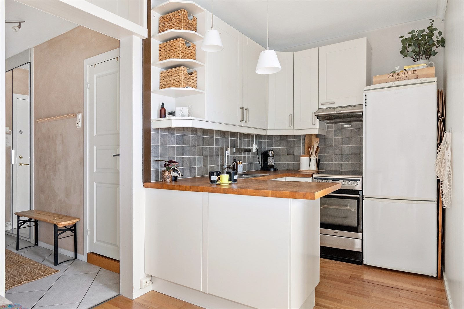 Godt utnyttet kjøkken med fliser over benk og heltre benkeplate Galleribilde