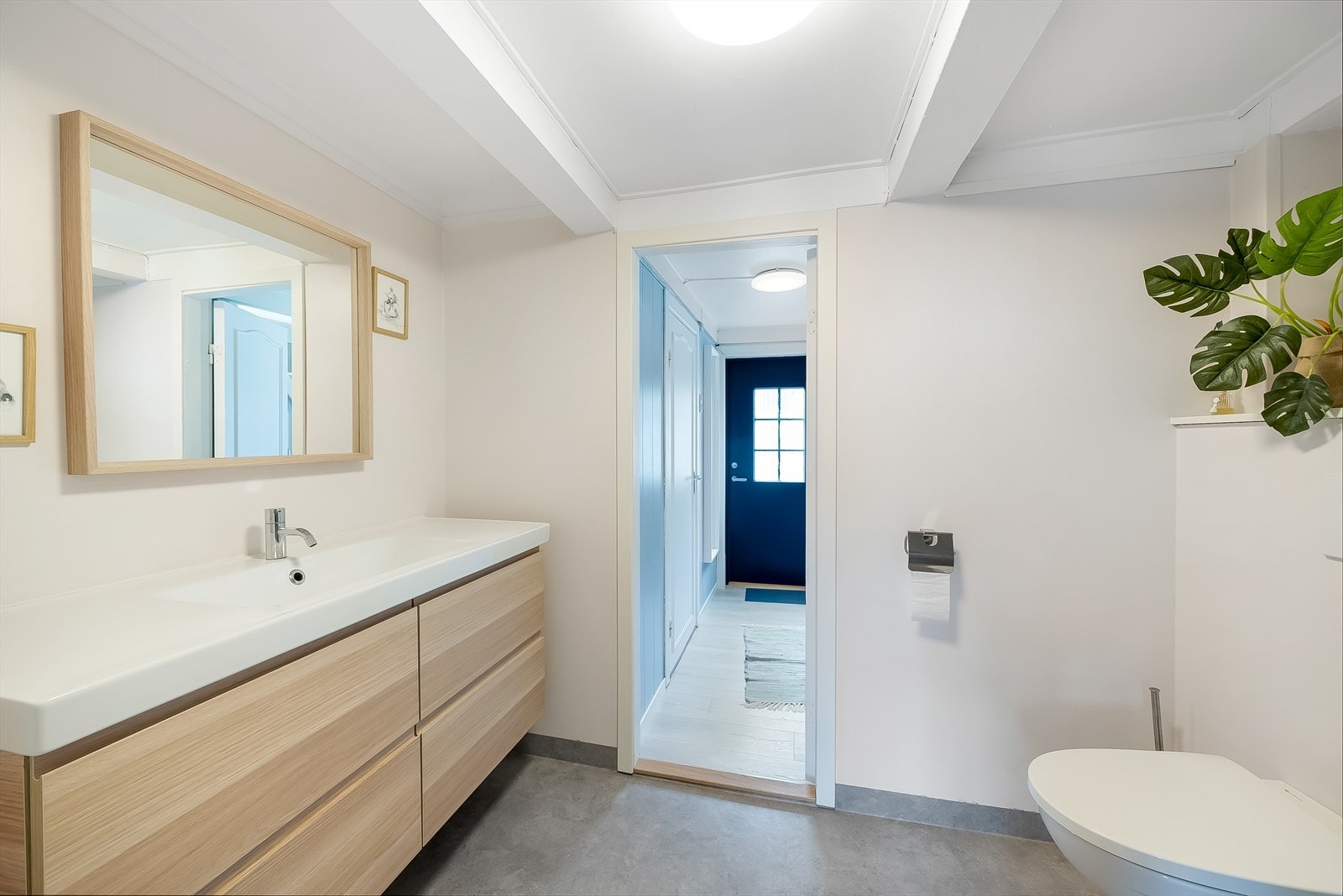 Pent innredet bad med belegg på gulv og malte vegger. Rommet er innredet med baderomsinnredning, toalett og dusjløsning. Galleribilde