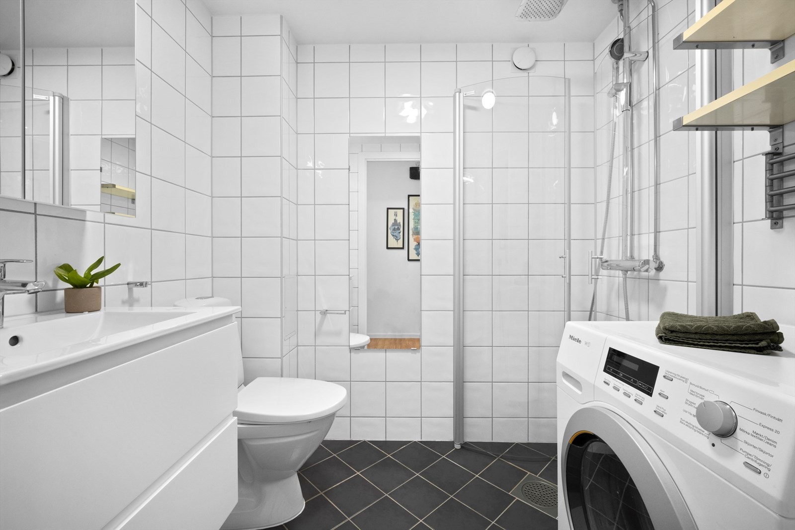Pent flislagt baderom med elektrisk gulvvarme og opplegg for vaskemaskin. Galleribilde