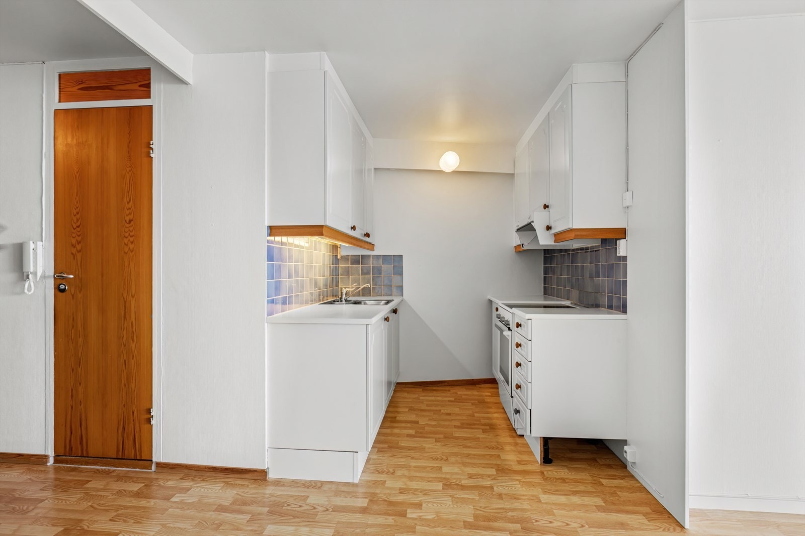 Kjøkkeninnredningen har hvite, profilerte fronter og benkeplate av laminat. Galleribilde