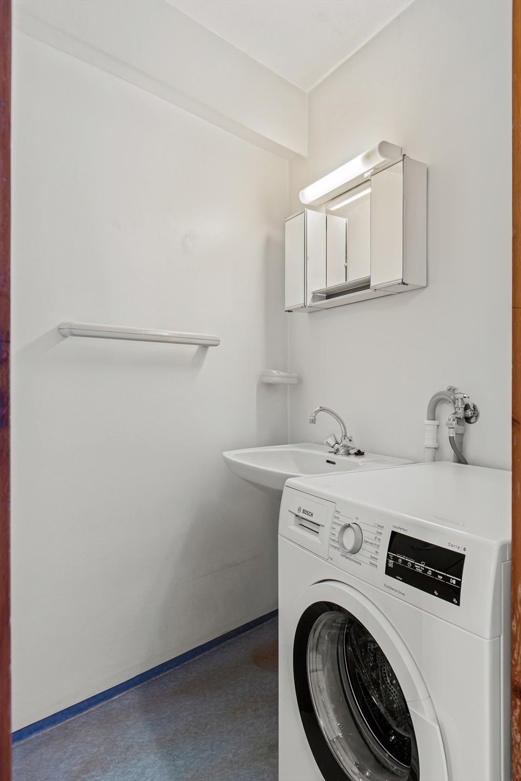 Badet er innredet med enkel servant og dusjhjørne, samt har opplegg for vaskemaskin. Galleribilde