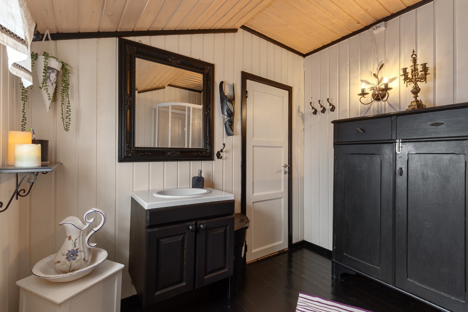 Stort baderom hvor det er montert hyttedusj, enkel servant og separett toalett villa Galleribilde