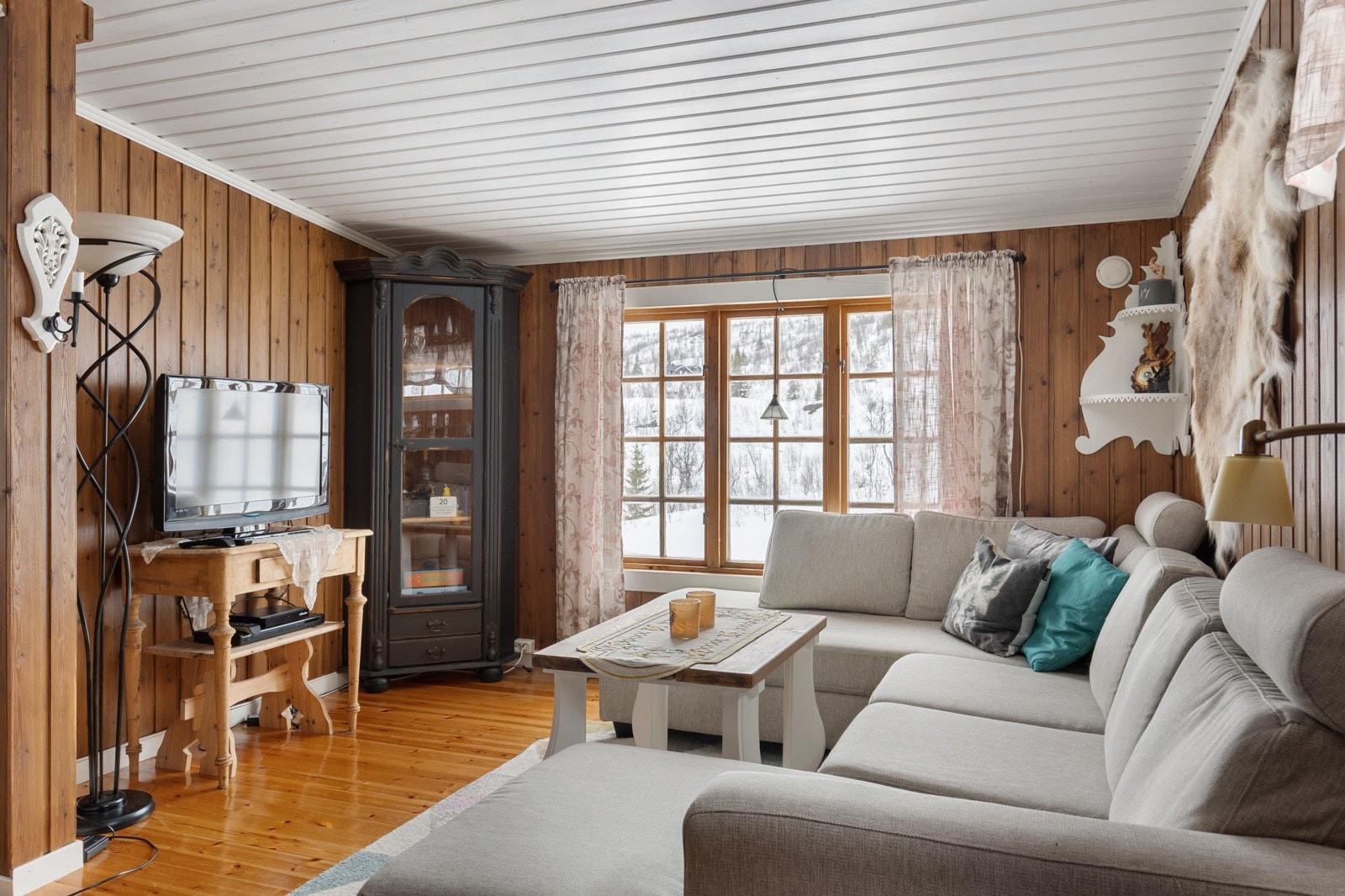 Stuen får godt med naturlig lys inn fra store vindusflater Galleribilde