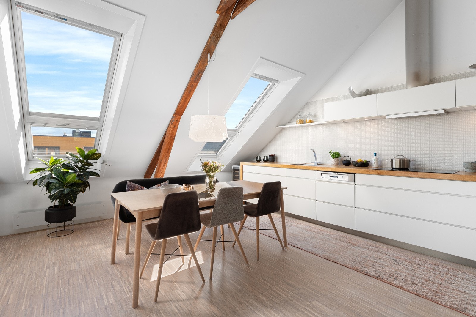 Kvik kjøkkeninnredning med hvite grepsfrie fronter og lys grå mosaikkfliser på vegg Galleribilde