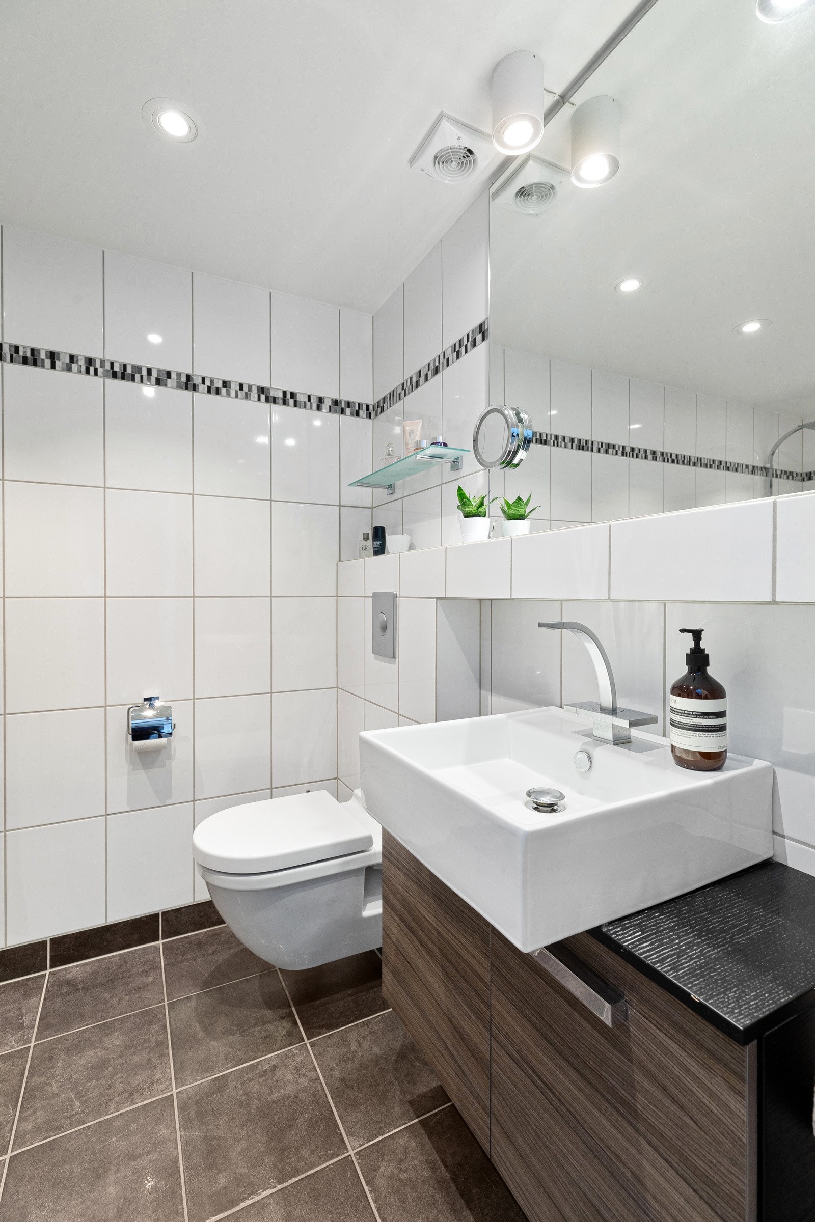 Flislagt bad med varmekabler, dusjnisje, veggmontert servantskap og toalett samt opplegg for vaskemaskin Galleribilde