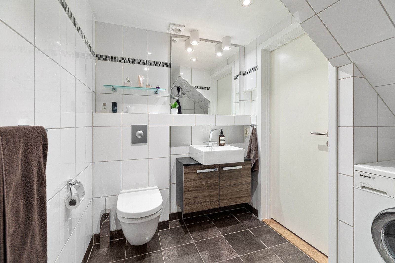 Veggmontert servantskap med utenpåliggende vask og to-greps armatur i krom Galleribilde