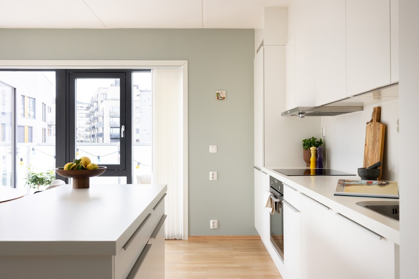 Kjøkkeninnredningen består av hvite, glatte fronter og benkeplate av laminat med nedfelt vaskekum. Galleribilde