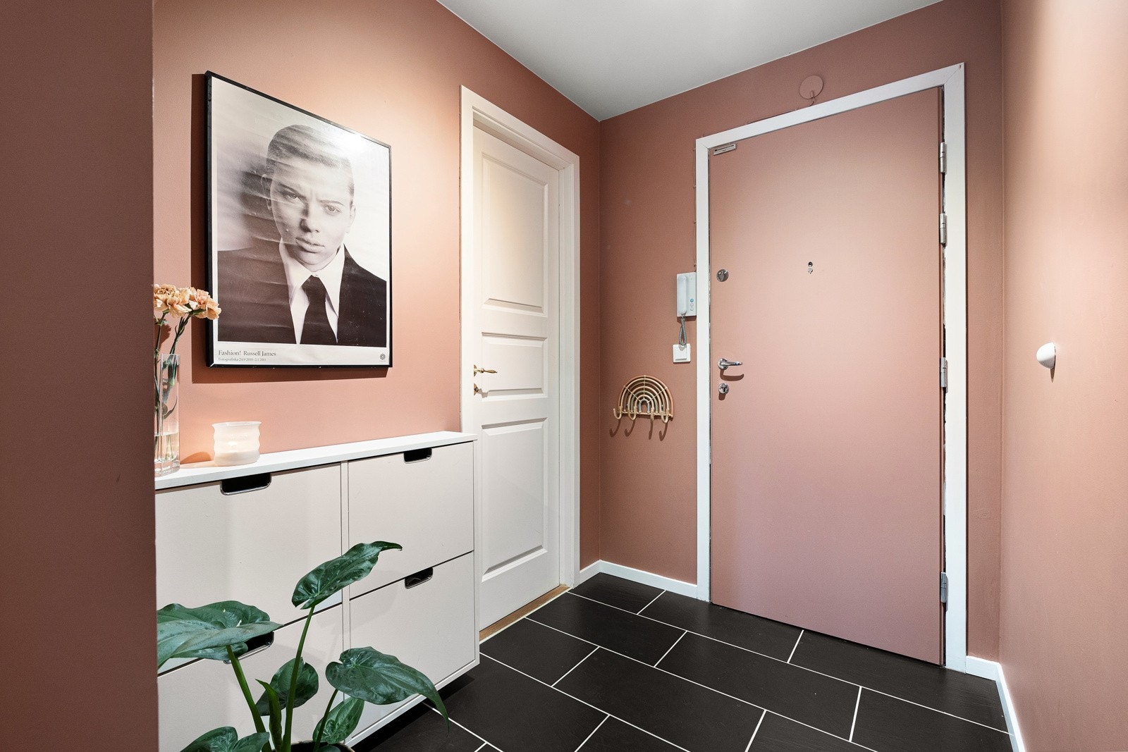 Innbydende entré med flislagt gulv og yttedør malt i veggfarge. I direkte tilknytning til entréen har man en praktisk bod. Galleribilde