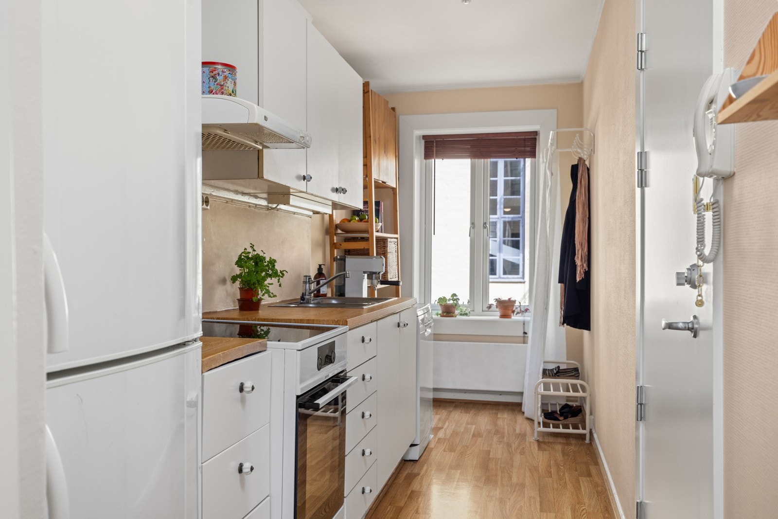 - Eldre kjøkkeninnredning med hvite, glatte fronter og god skap- og benkeplass - Galleribilde