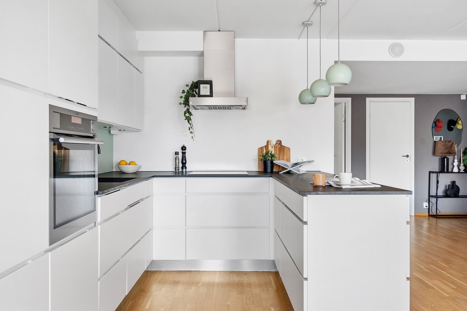 Stilrent Kvik-kjøkken fra 2015 med hvite fronter og laminert benkeplate. Det er rikelig med skap- og benkeplass for matlaging og oppbevaring. Galleribilde