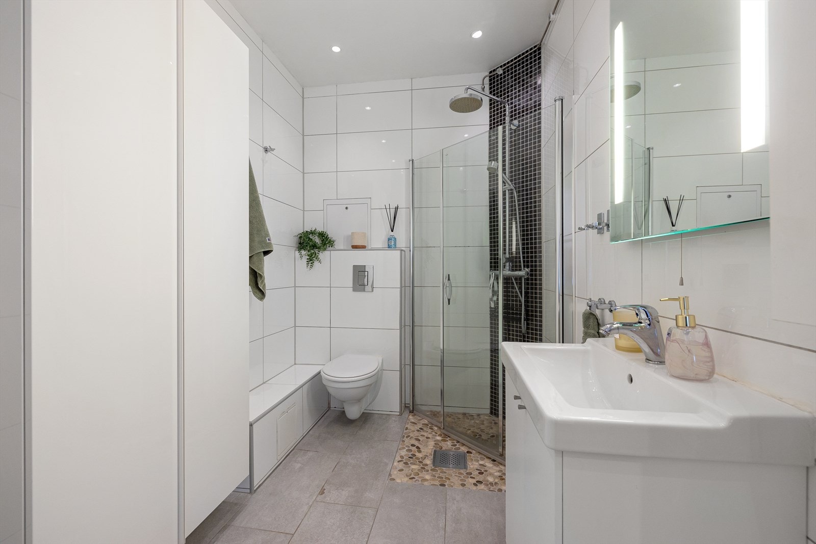 Delikat bad fra 2012 med flislagte overflater og downlights i himling. Galleribilde