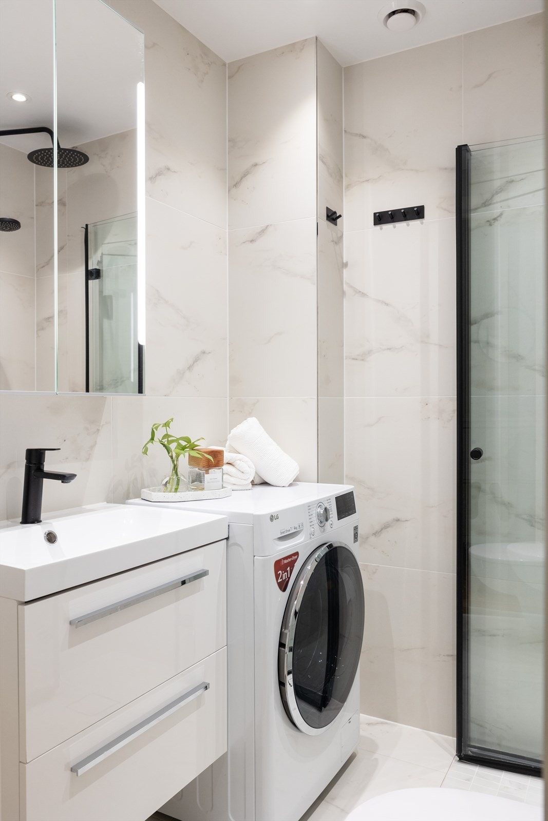 Moderne baderom med gulvvarme, opplegg for vaskemaskin og downlights i tak Galleribilde