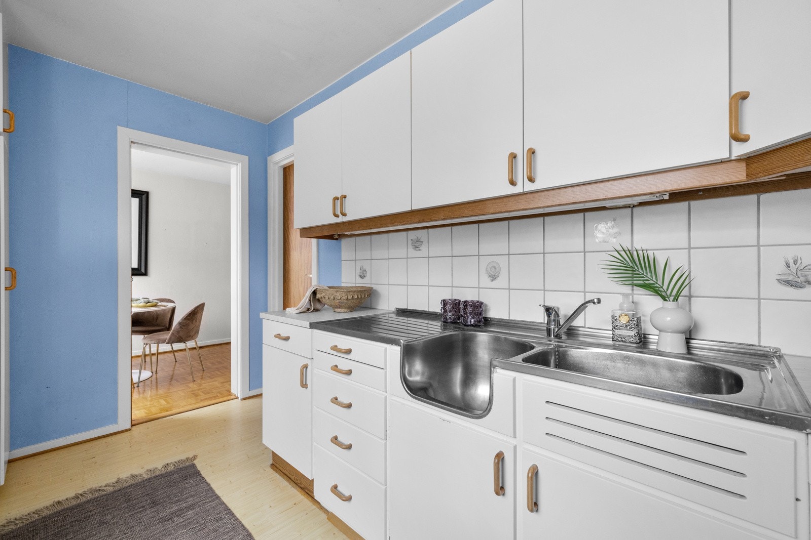 Innredningen har glatte fronter, laminat benkeplate og heldekkende kum i rustfritt stål. Galleribilde
