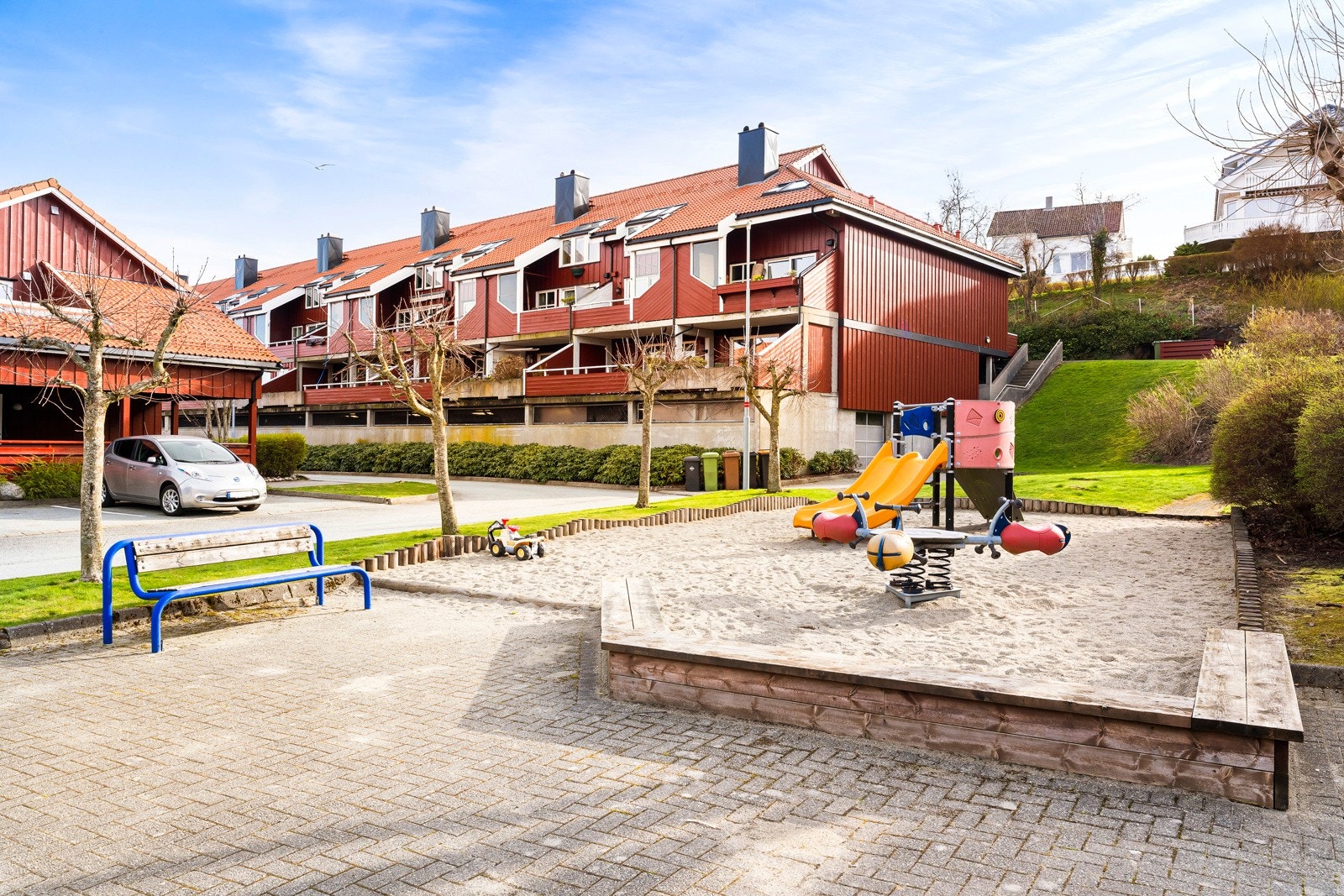 Fellestomten er pent opparbeidet med asfalterte internveier, vakre prydbusker og stemningsfull utebelysning, og det er etablert et sosialt uteområde med lekestativer og sittebenker på tunet mellom bygningene. Galleribilde