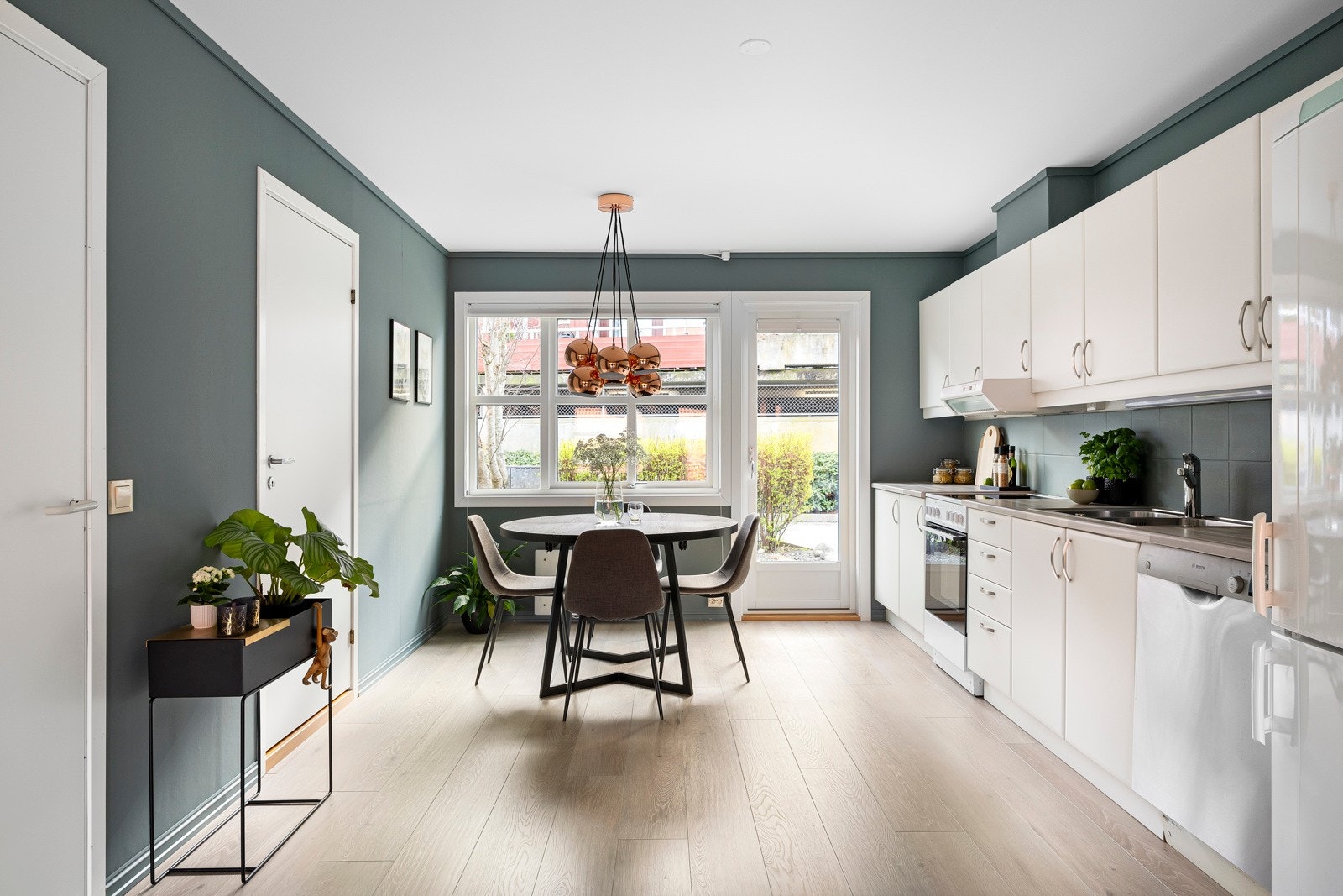 Innredningen har hvite, glatte fronter og lys laminatbenkeplate med nedfelt kum i stål. Galleribilde