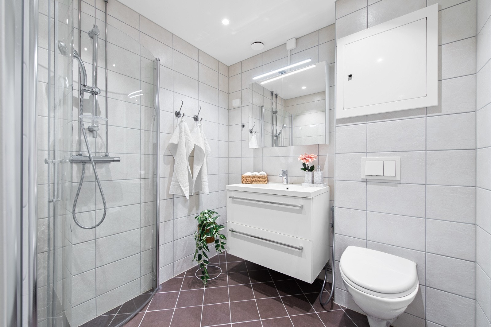 Slett baderomsinnredning med helstøpt servant og 1-greps blandebatteri. Speilskap over servant. Galleribilde