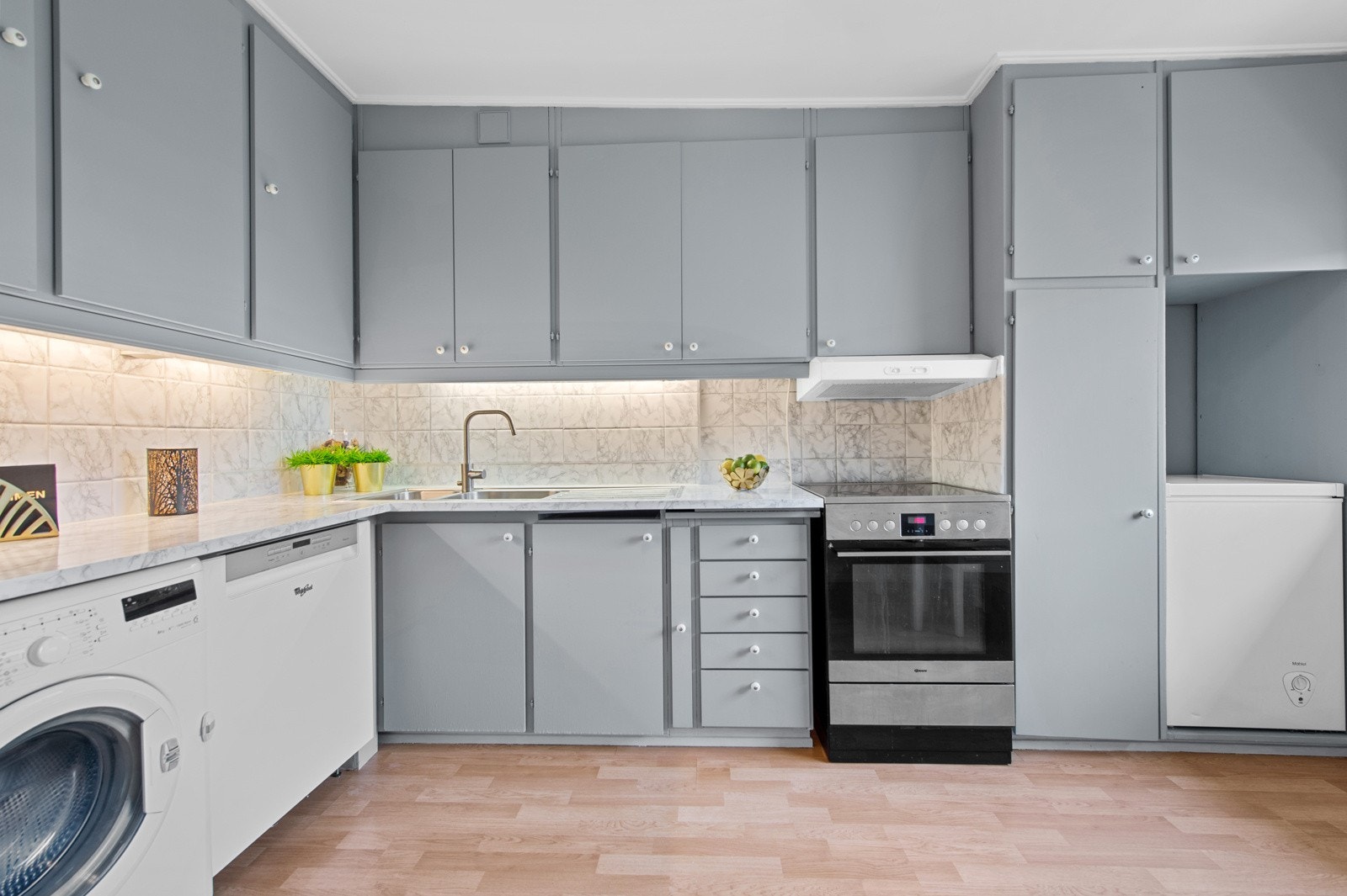 Separat kjøkken med god skapplass til diverse kjøkkenutstyr. Benke- og overskap med slette fronter og benkeplate av laminat/foliert. Galleribilde