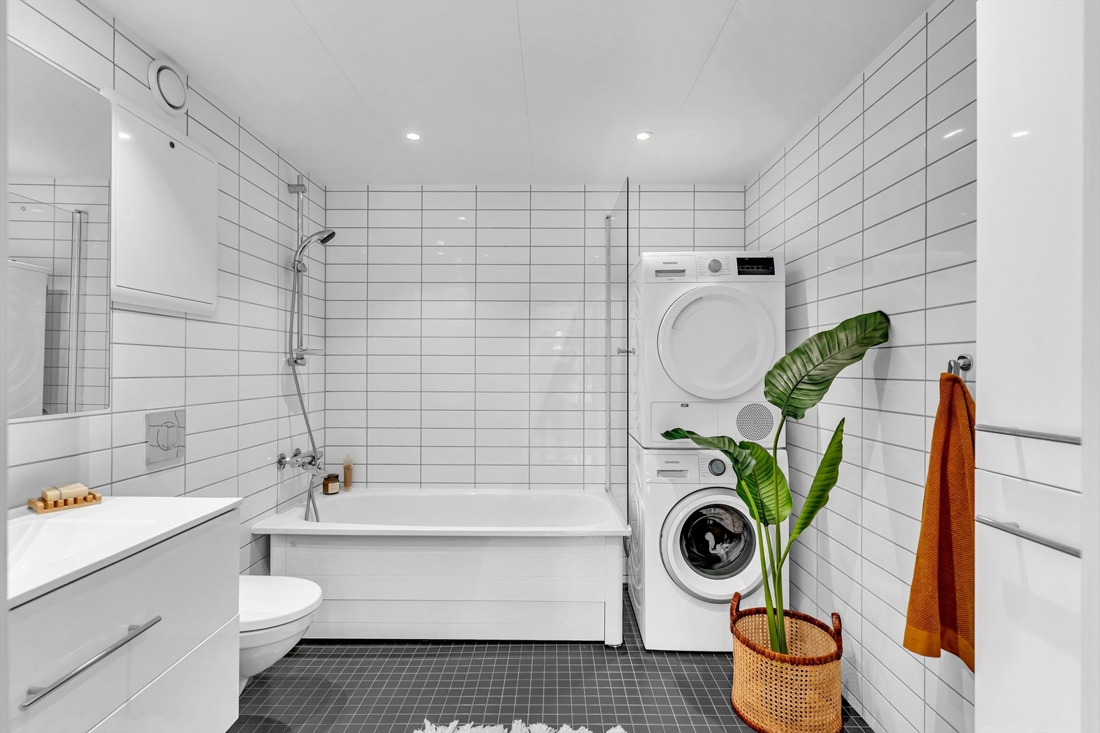 Leiligheten har et stort bad med badekar. Det er varmekabler i gulv og plass til vaskesøyle. Galleribilde