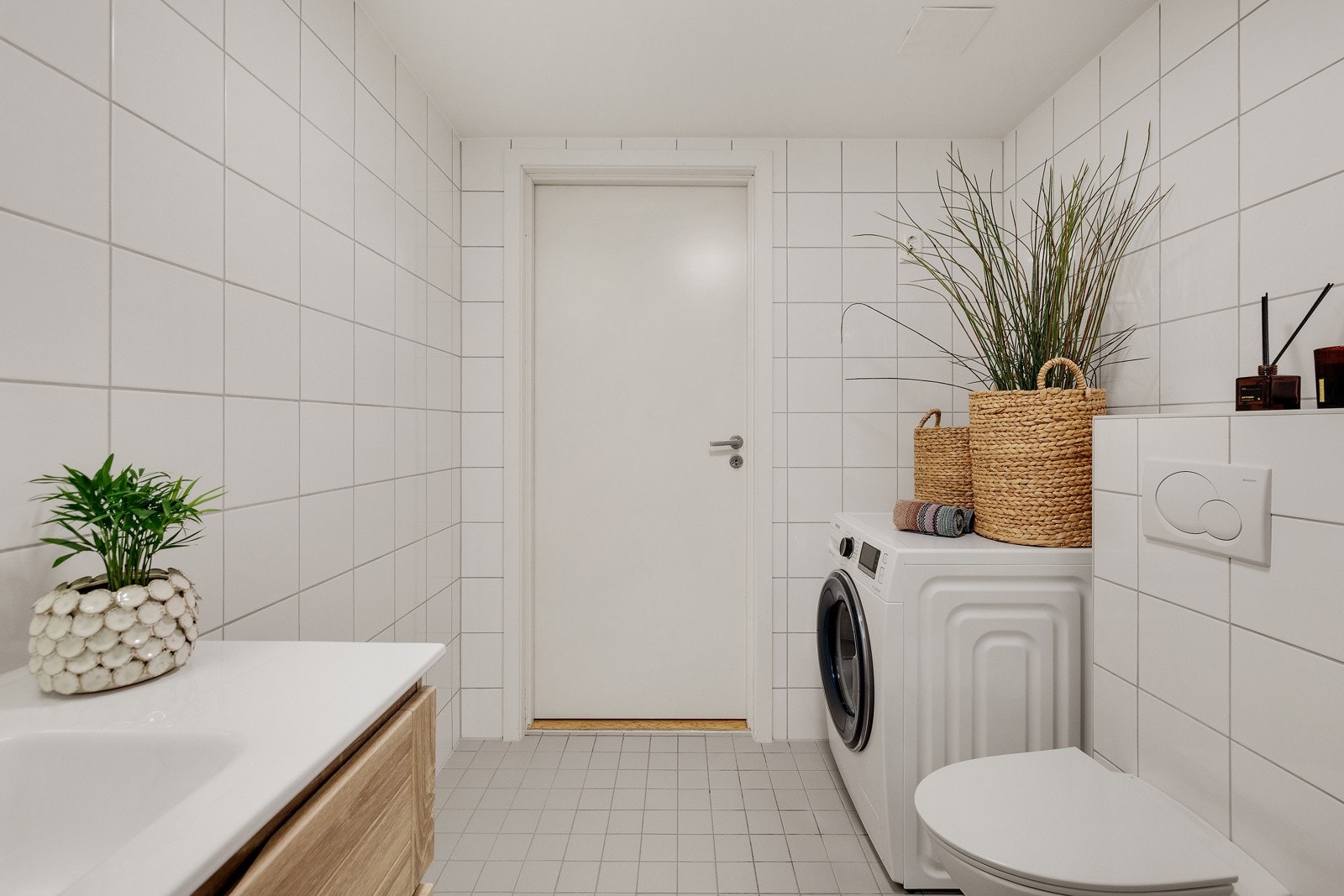 Baderommet har grå fliser på gulv, hvite fliser på veggene og deilig gulvvarme Galleribilde