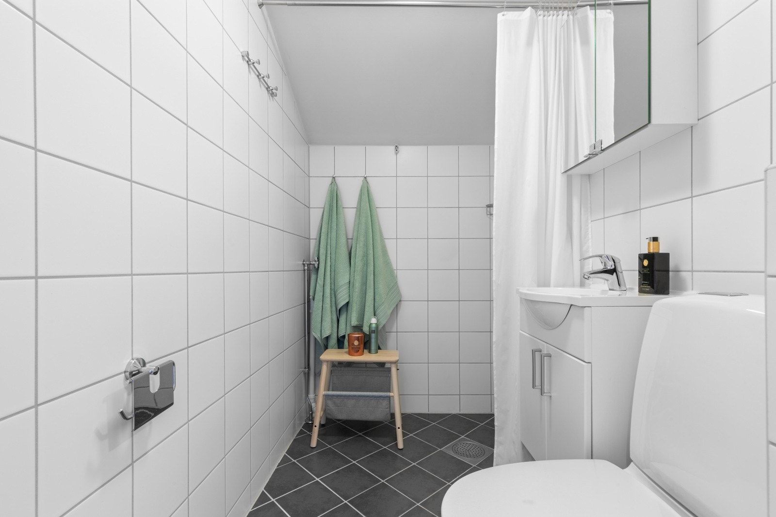 I gulvet er det termostatstyrte varmekabler. Badet består videre av klosett, servant med tilhørende innredning og speil Galleribilde