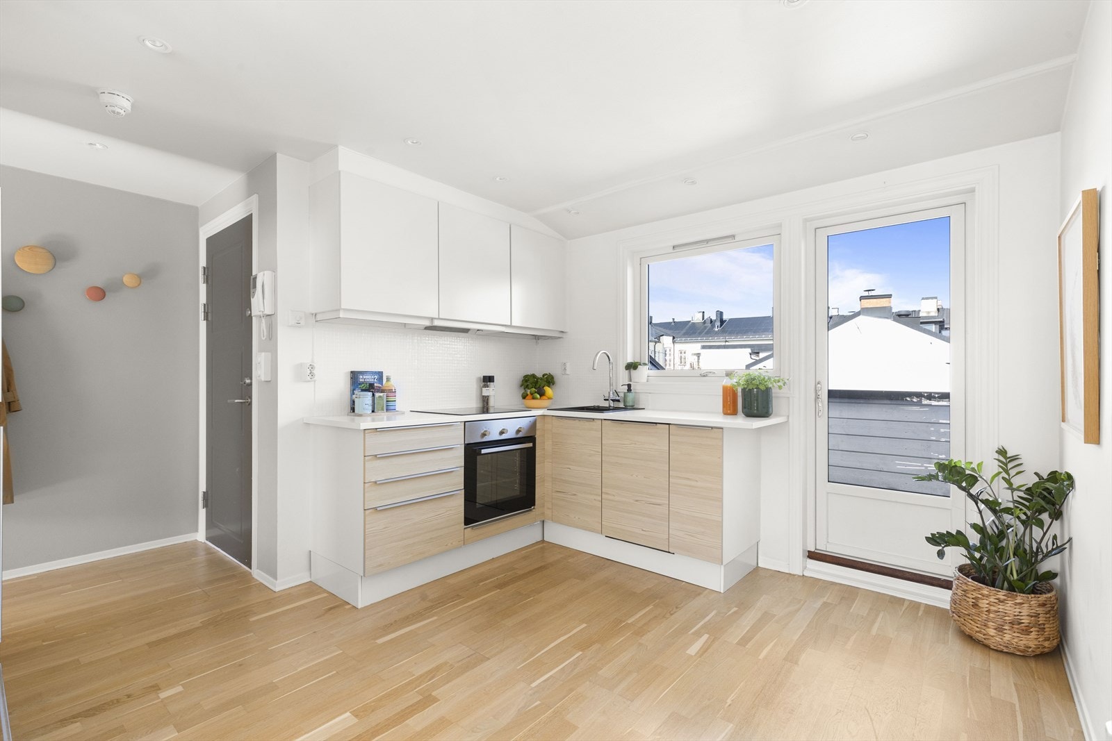 Stilren og moderne kjøkkeninnredning med finérte/folierte fronter og laminert benkeplate med nedfelt komposittkum. Galleribilde