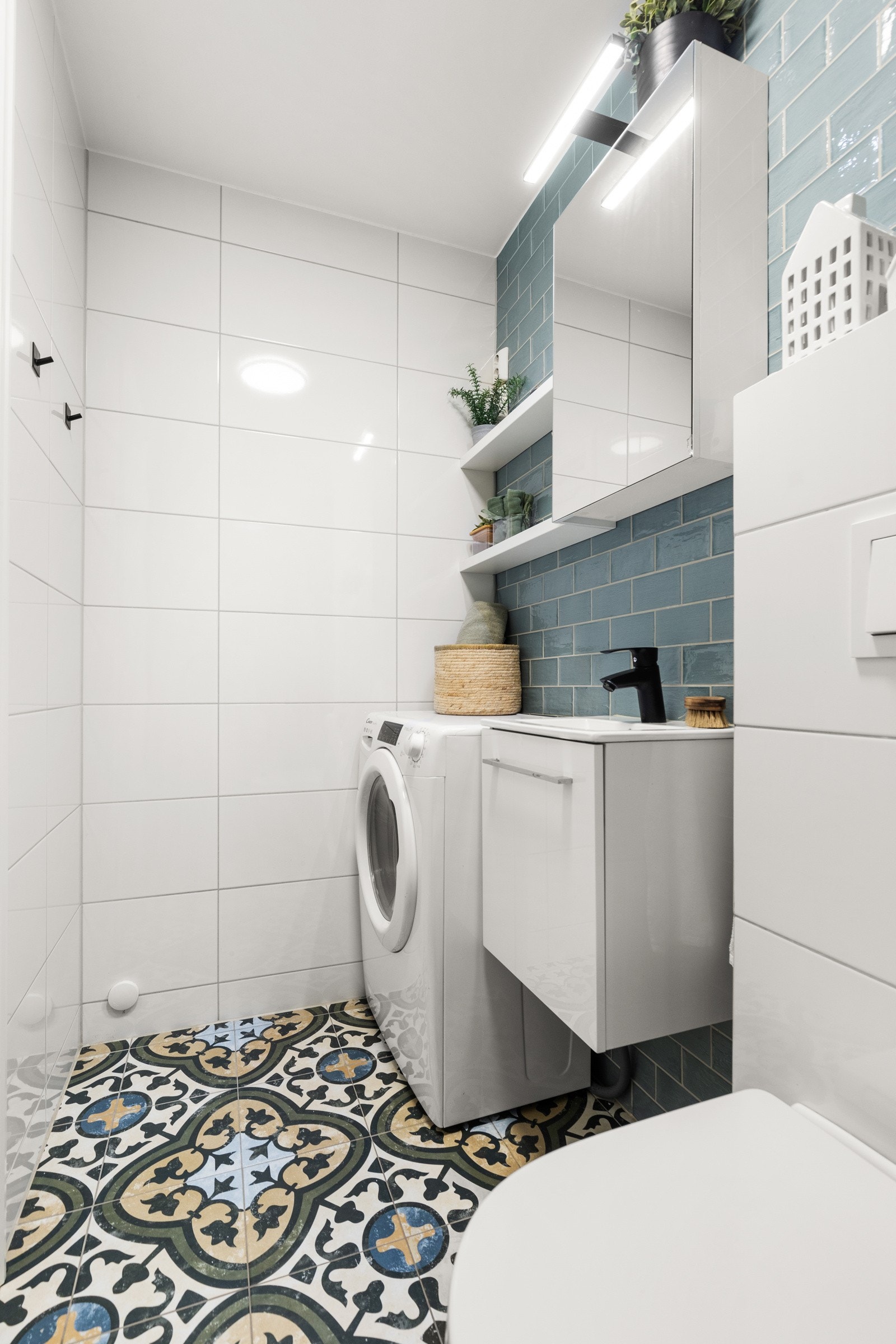 Badet er utstyrt med dusj med innfellbare glassvegger, servantseksjon med skuffer og heldekkende porselensvask, speilskap med lys og stikkontakt, vegghengt wc og opplegg for vaskemaskin/tørketrommel. Galleribilde