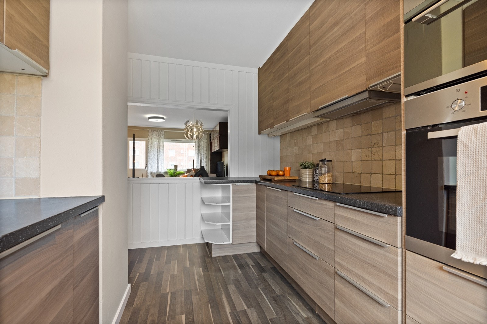 Innredningen har brune, glatte fronter med tremønster og benkeplater i mørk laminat. Galleribilde