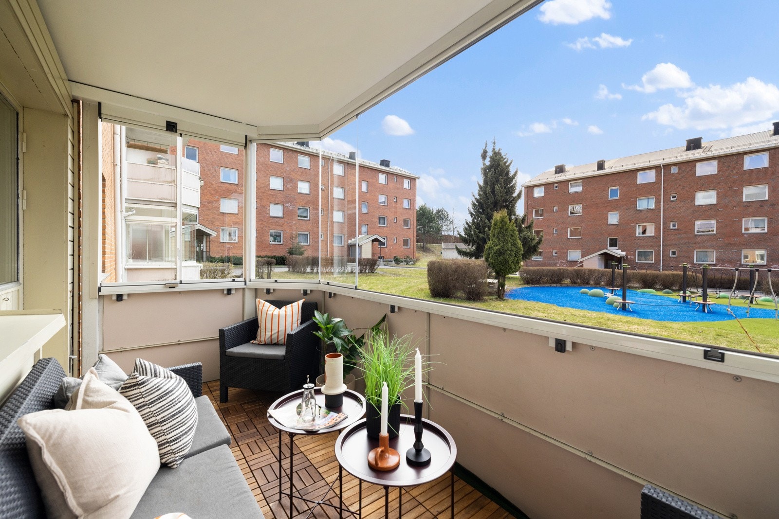 Balkongen har dekke av treheller over betong, tett rekkverk, utebelysning, overbygg, og innglassing som kan skyves til side for å slippe inn luft på de varmeste dagene. Galleribilde