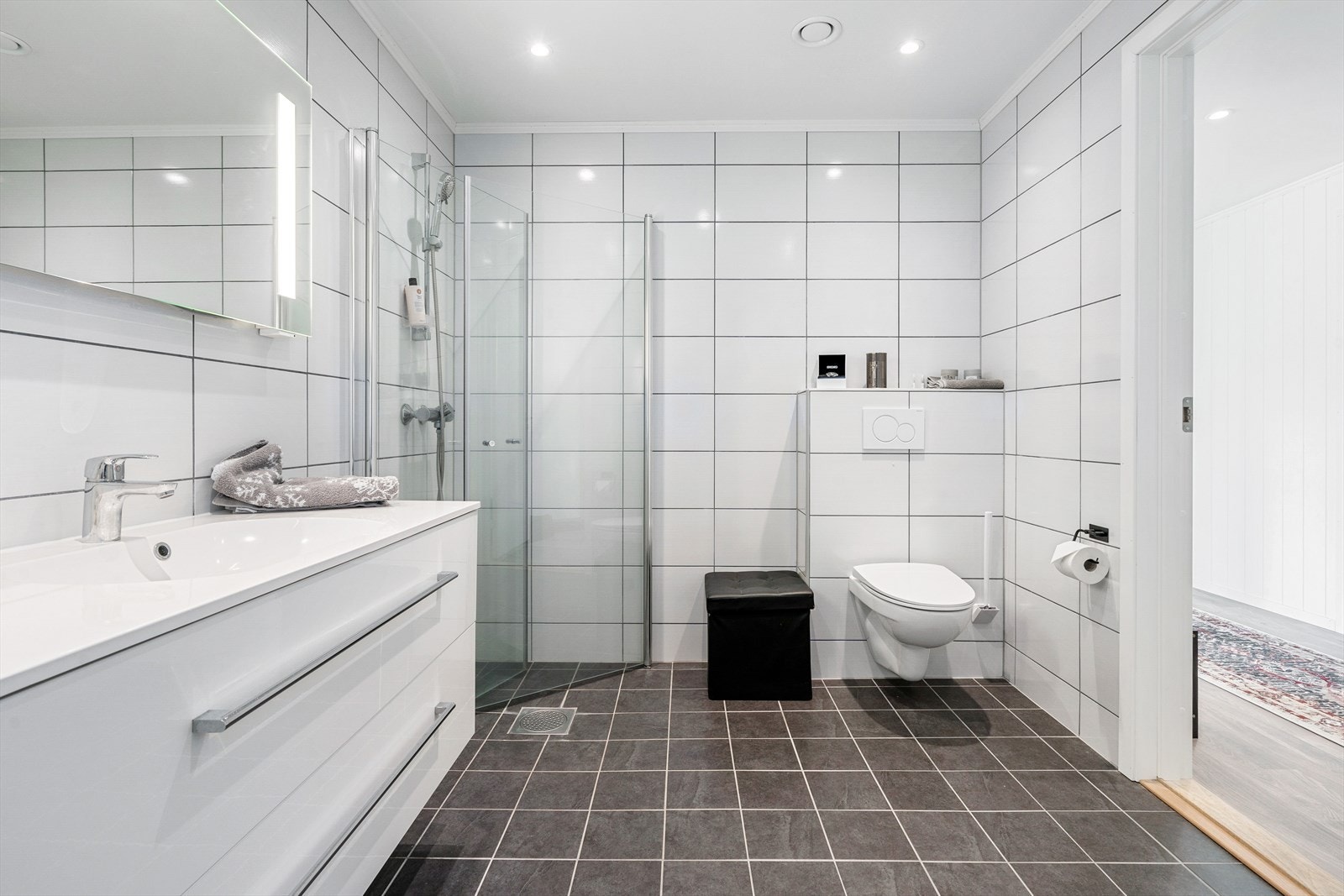Badet er innredet med dusjhjørne, toalett og servant på baderomsinnrending. Galleribilde