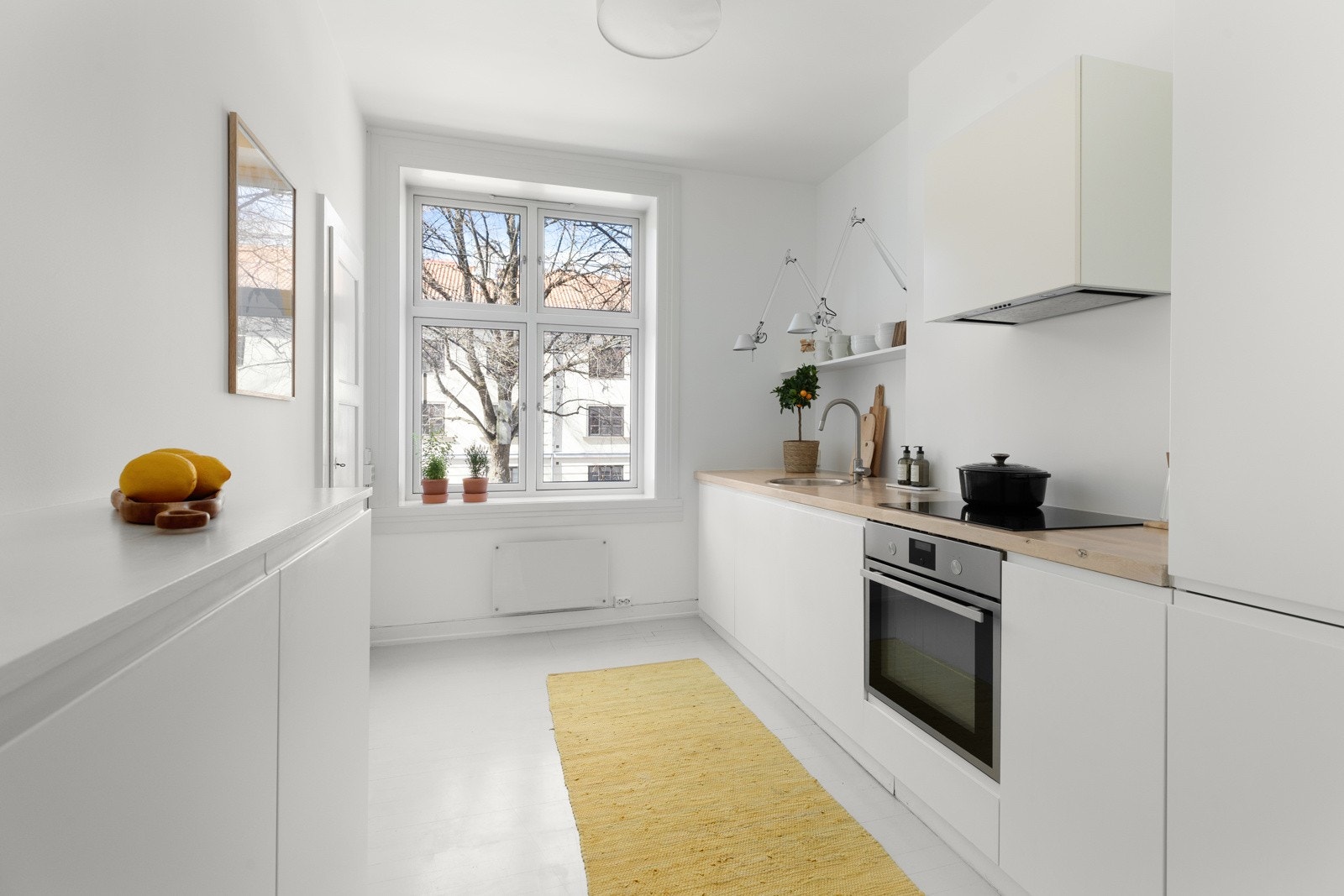 En elegant kjøkkeninnredning med hvite, håndtaksløse fronter Galleribilde