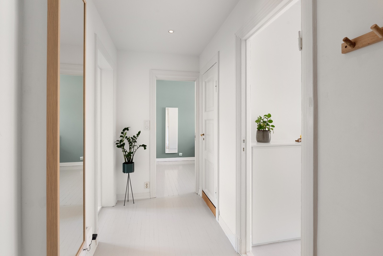 En innbydende og romslig inngang med tilstrekkelig lagringsplass for yttertøy og sko. Inngangen fungerer som et sentralt gjennomgangsrom i leiligheten, med tilgang til alle andre rom Galleribilde