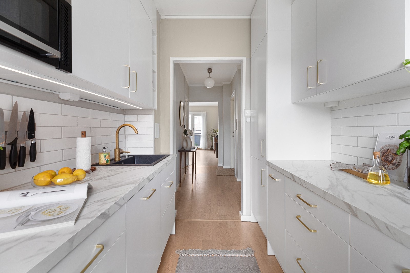 Innredning på to vegger med overskap, benkebelysning og fliser på vegger Galleribilde