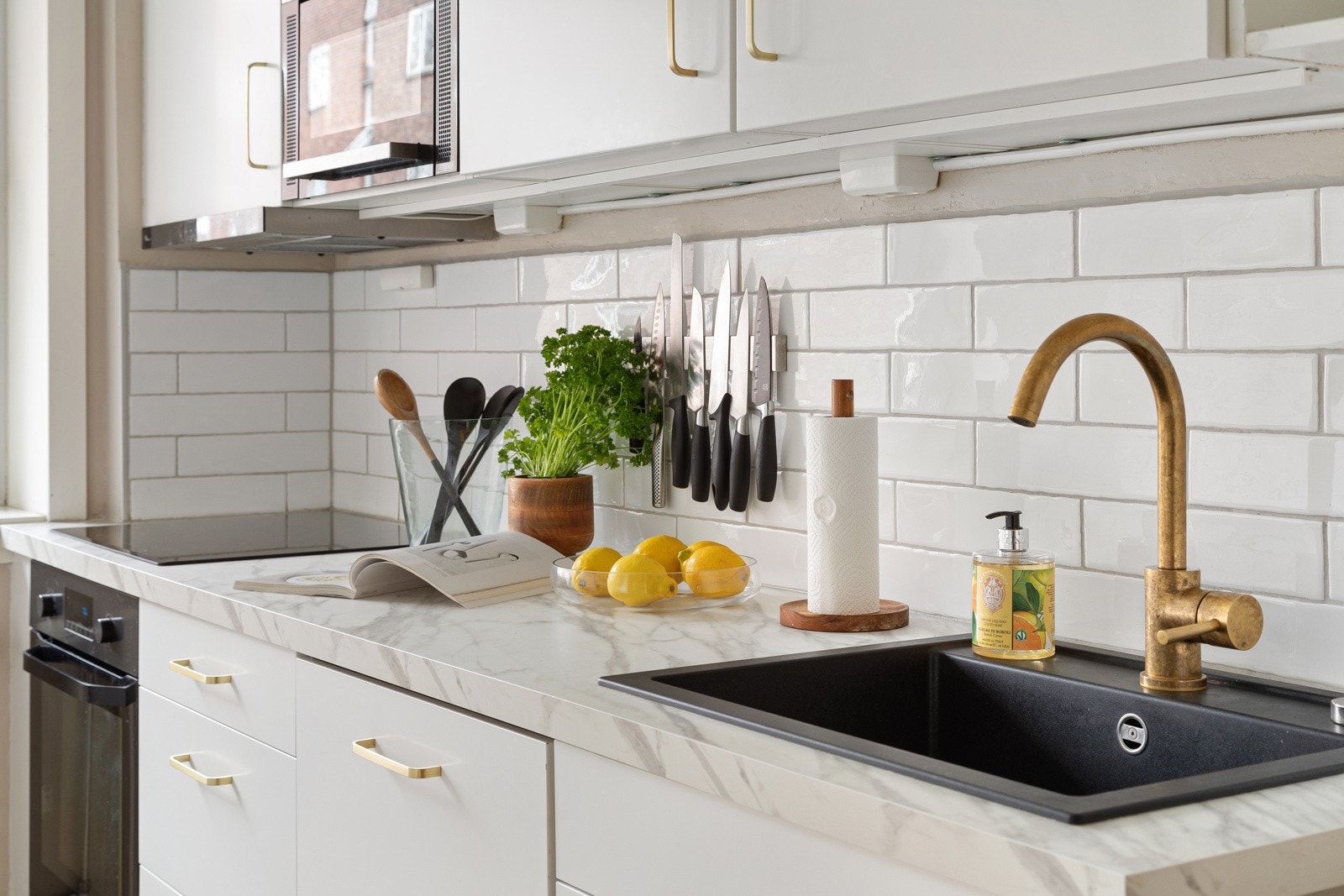 Lys laminat benkeplate med nedfelt sort komposittvask og ett-greps armatur i messing Galleribilde