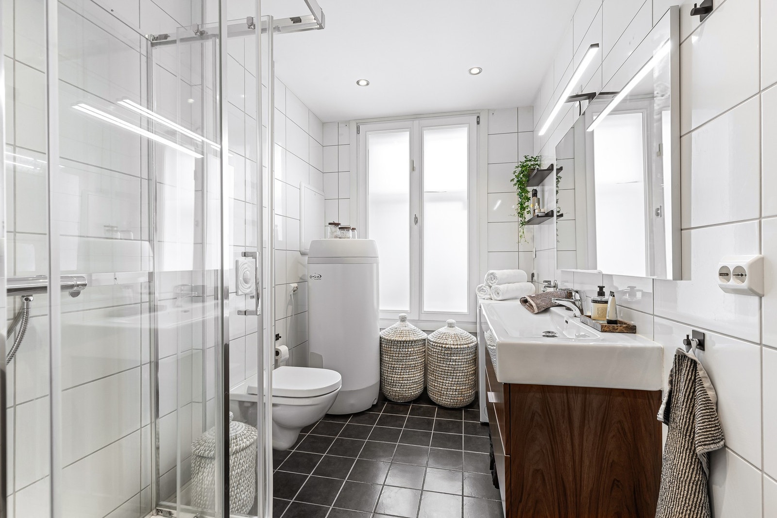 Badet har fliser på vegg, malt tak og flislagt gulv med elektriske varmekabler. Galleribilde