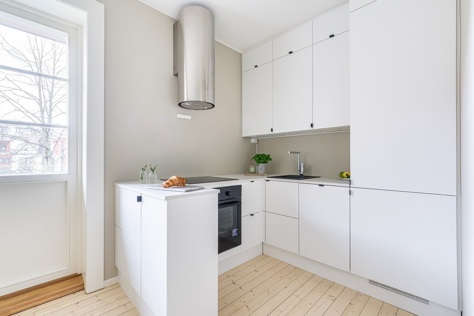 Kjøkkeninnredning med lyse, glatte fronter og benkeplate av laminat Galleribilde
