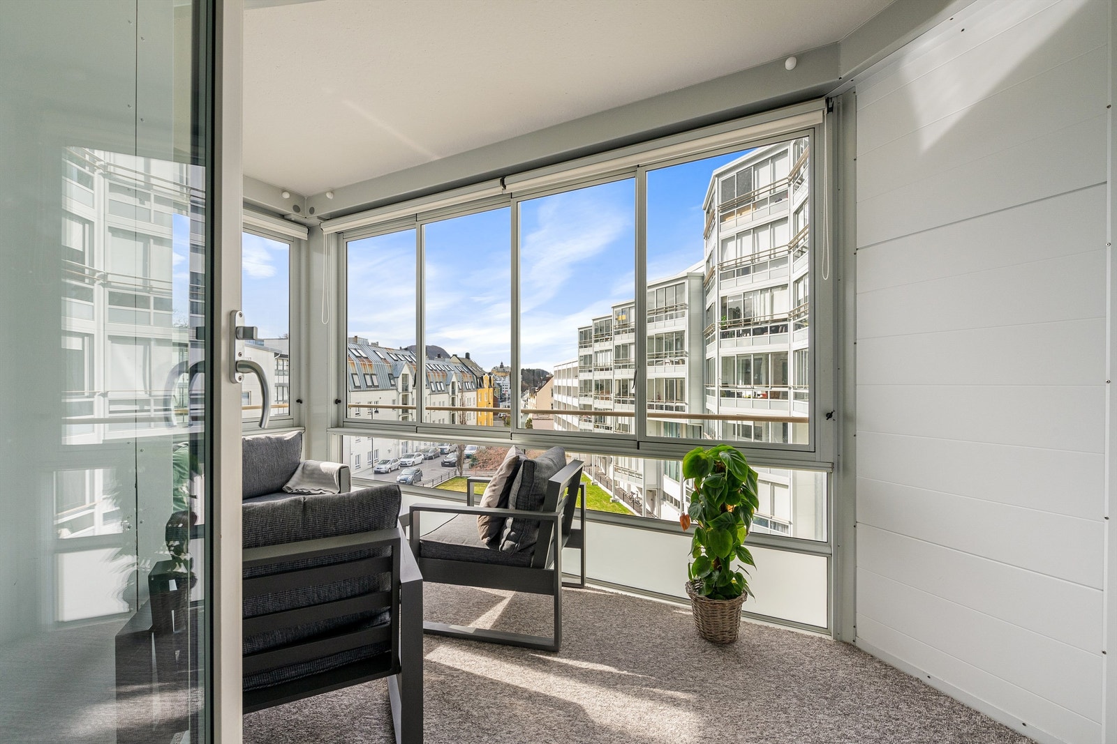 Romslig innglasset balkong med god plass til sittegruppe og utsikt mot bysentrum Galleribilde