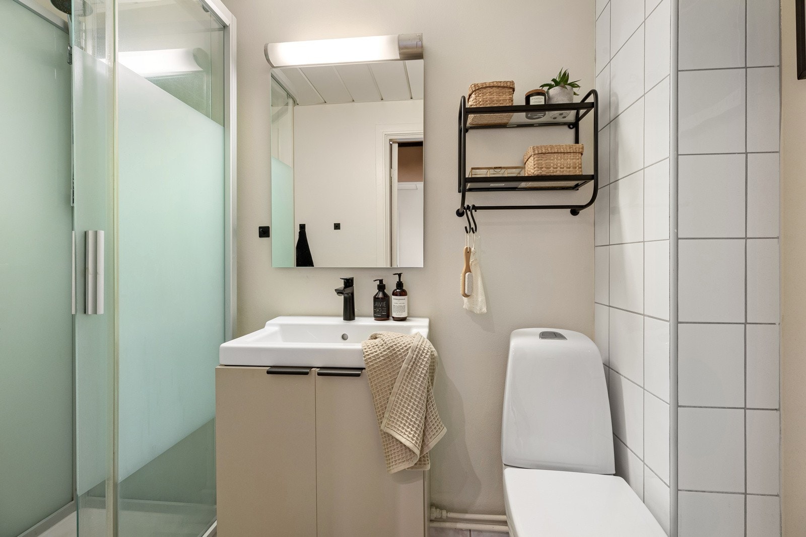 Baderom med lys innredning og et stilrent utseende. Opplegg for vaskemaskin på soverommet Galleribilde