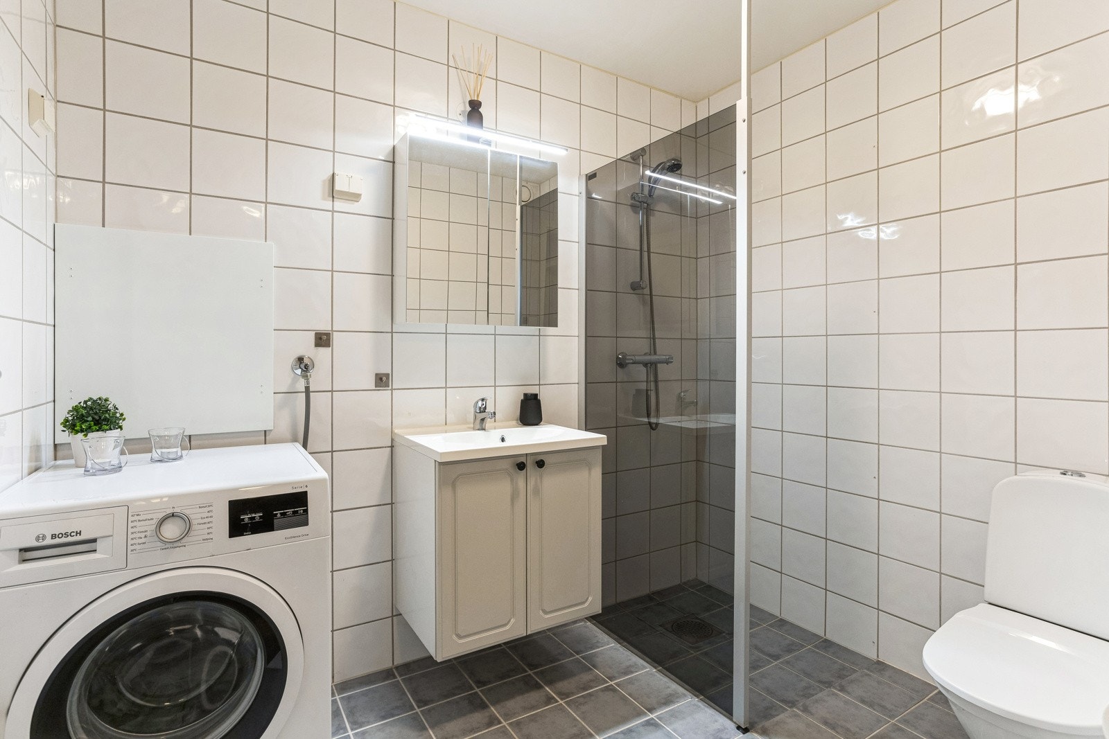 Romslig og flislagt baderom med elektrisk gulvvarme. Galleribilde