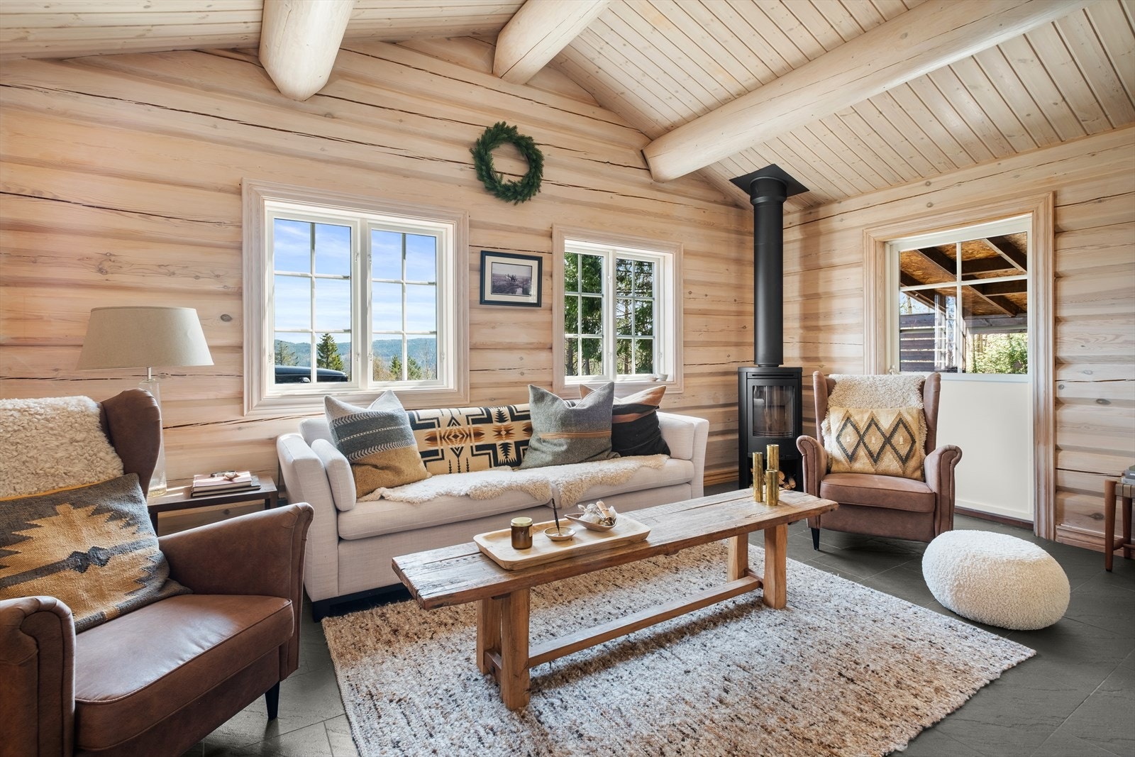 Det er god takhøyde i stuen og det er peisovn og utgang til terrasse i stuen Galleribilde