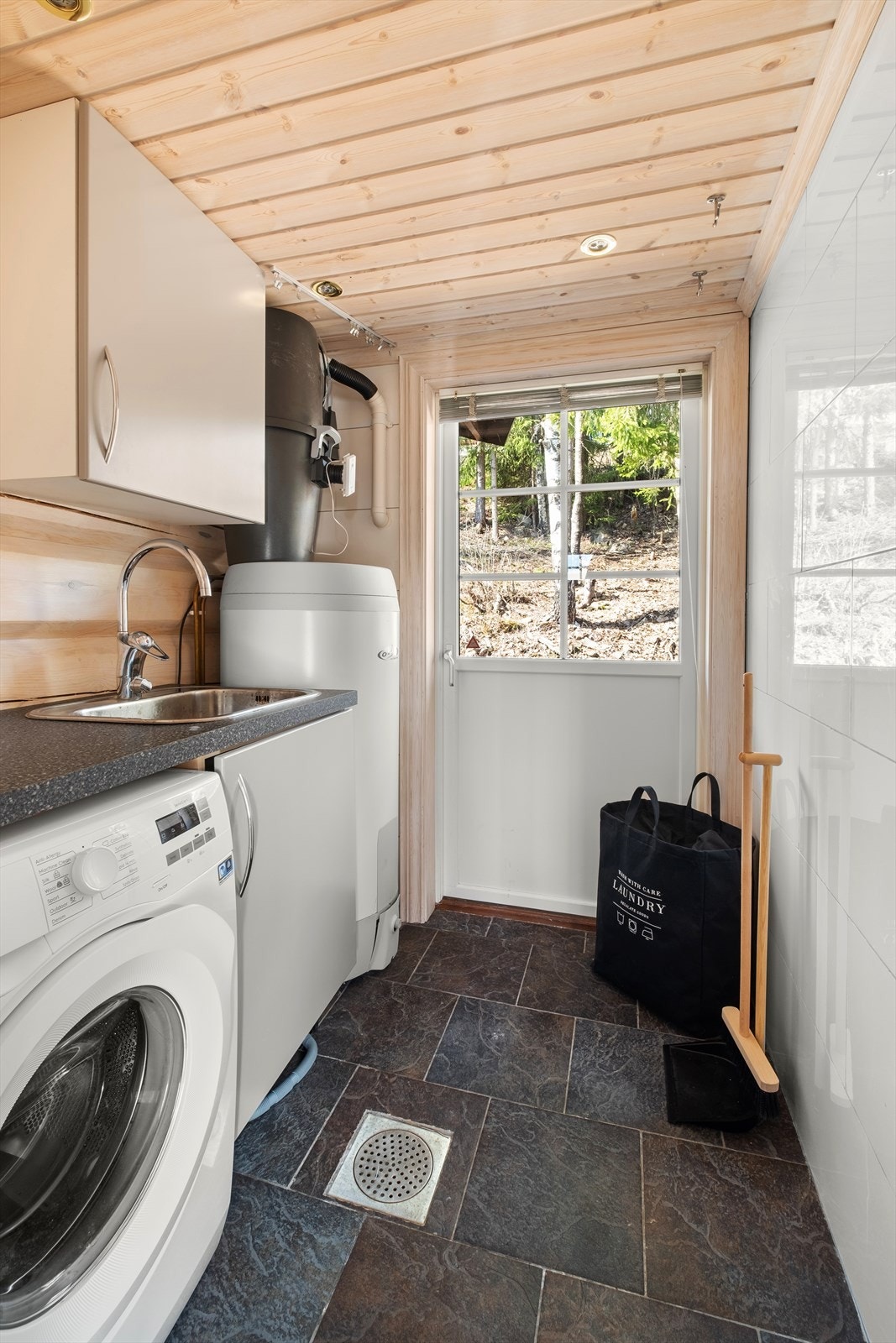 Vaskerommet er flislagt med varmekabler og har opplegg for vaskemaskin og praktisk utgang bak hytta Galleribilde