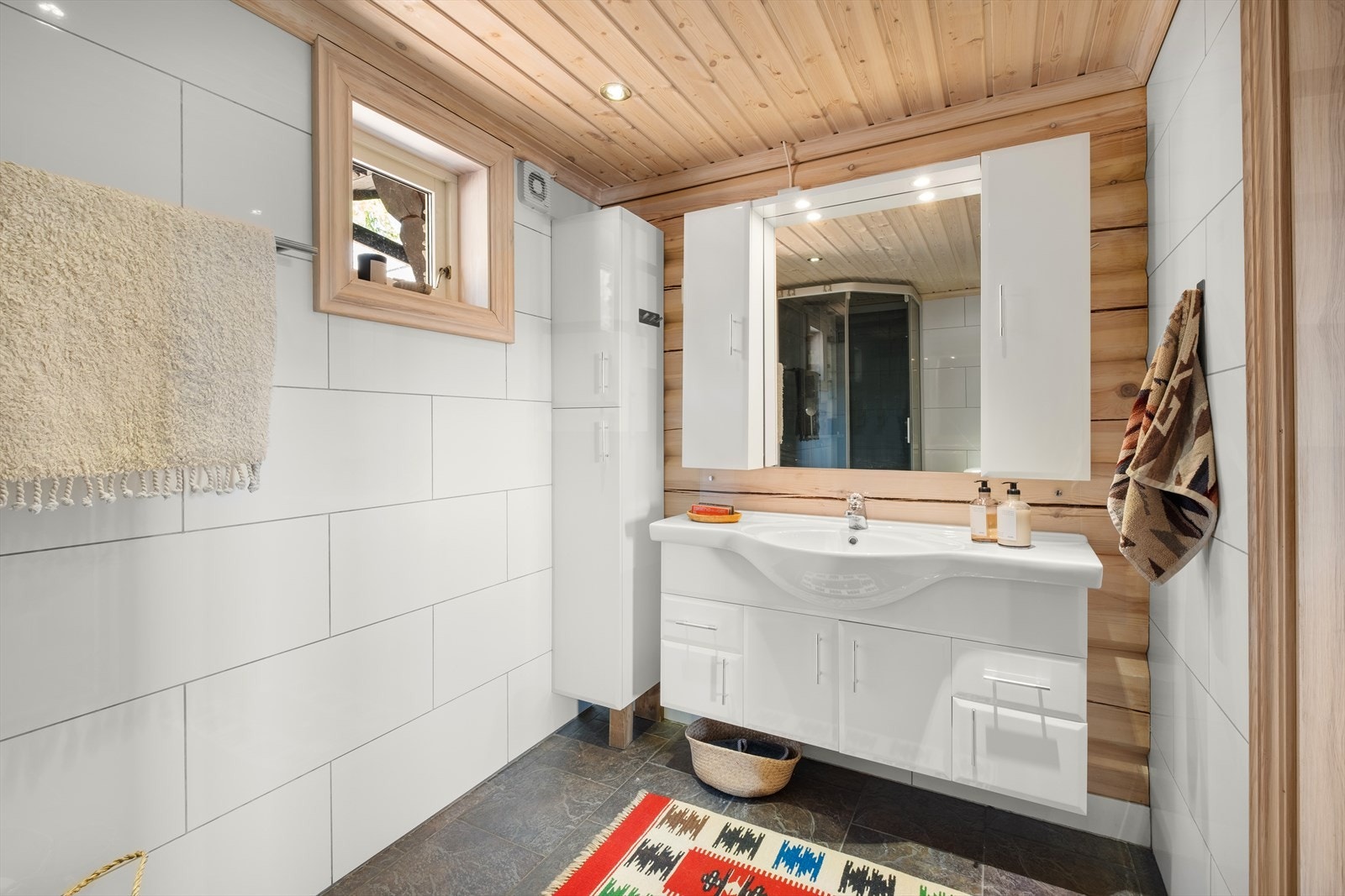 Badet er flislagt med varmekabler i gulv. Innredet med dusjnisje, toalett og servant Galleribilde