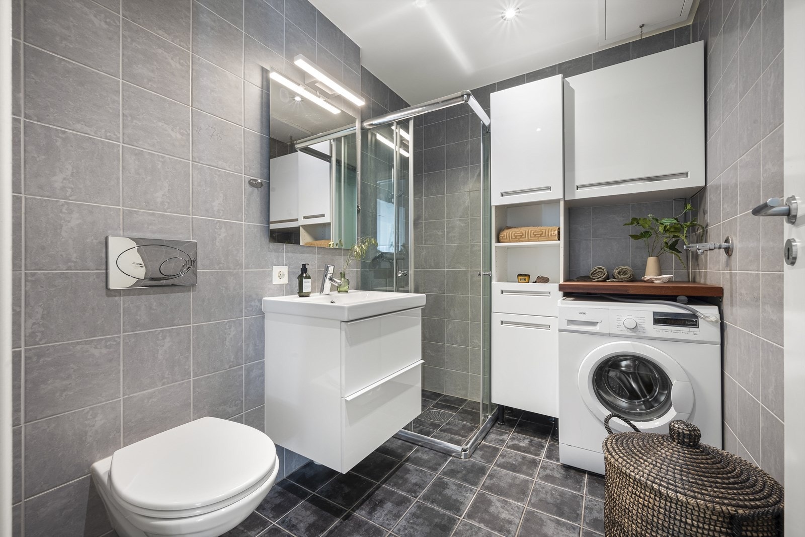 Pent flislagt bad fra 2010 med fine overflater, elektriske varmekabler og downlights i tak. Galleribilde